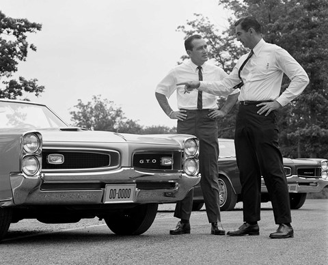 Pontiac general manager John DeLorean (right) talks with Dick Day about the 1966 GTO (Getty)