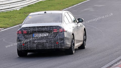 New 2023 BMW i5 spy shots: rear three quarter driving, camouflaged car, track testing