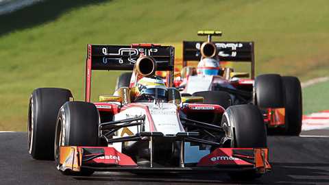 HRT’s Pedro de la Rosa and Narain Karthikeyan proceed slowly to the exit in 2012 