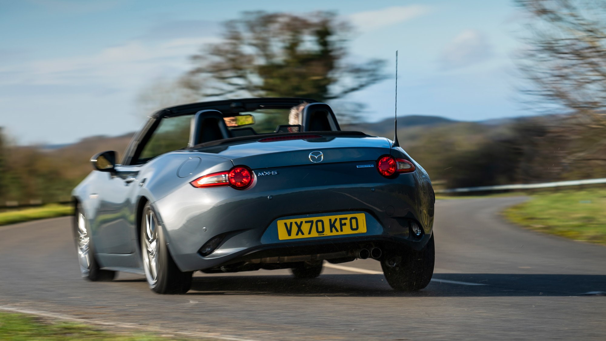 Mazda MX-5 review, rear view, driving round corner