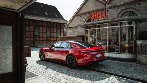 Porsche Panamera GTS: rear three quarter static, red paint, old Shell garage in the background