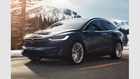 Driving shot of Tesla Model X with mountains in the background