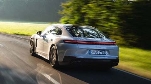 Porsche Panamera Turbo S E-Hybrid (2024) review: rear three quarter driving, silver paint, low angle, sunset