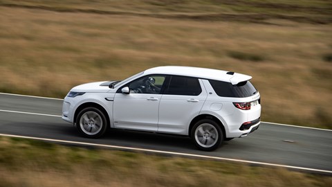 White Land Rover Discovery Sport P300e side elevation driving