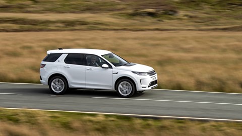 White Land Rover Discovery Sport P300e side elevation driving