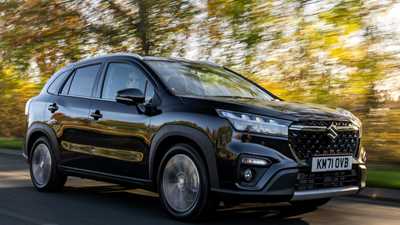Suzuki S-Cross (2022) review: front three quarter driving shot, wooded back road, blue car