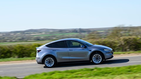 Tesla Model Y (2025) review: side view driving, close up, silver paint