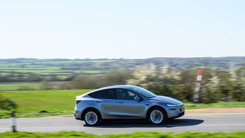 Tesla Model Y (2025) review: side view driving, long lens, silver paint