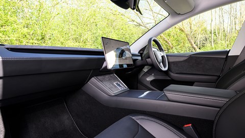 Tesla Model Y (2025) review: front seats, dashboard and infotainment system, black faux leather upholstery
