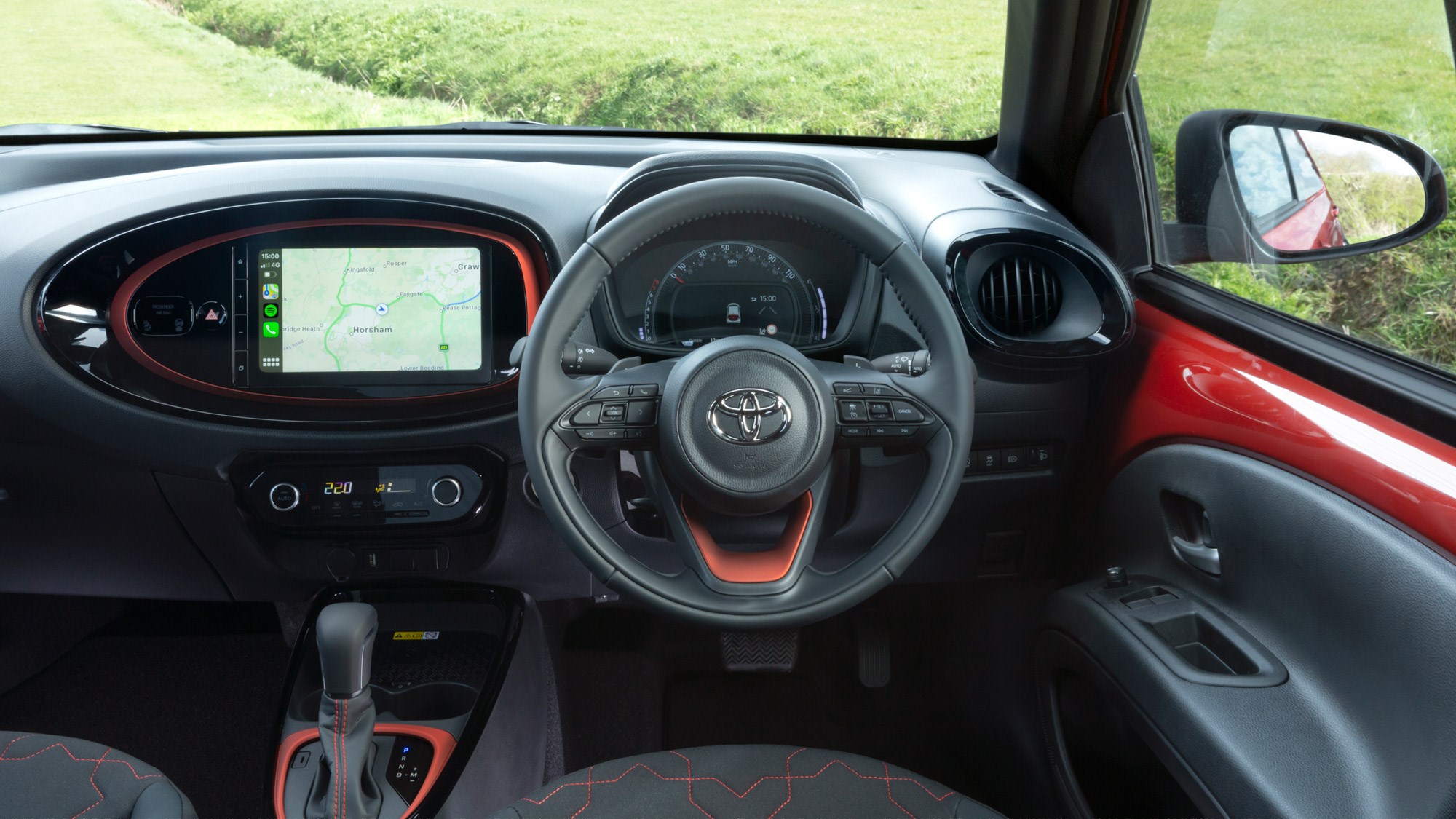 Toyota Aygo X right-hand-drive interior, steering wheel, dashboard, orange highlights
