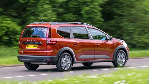 Dacia Jogger Hybrid (2023): rear three quarter driving, country lane, orange car