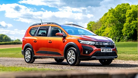 Dacia Jogger Hybrid (2023): front three quarter static, farmyard, orange car