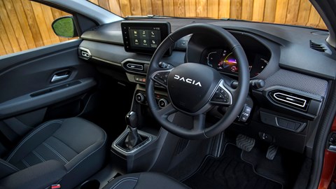 Dacia Jogger Hybrid (2023): dashboard and infotainment system from driver's seat, black upholstery