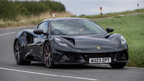 Lotus Emira (2023): front cornering, black paint, country lane