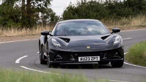 Lotus Emira (2023): front cornering, showing (some) body roll, black paint, country lane