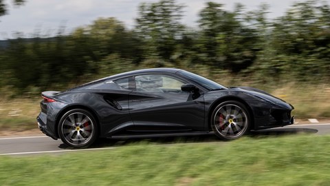 Lotus Emira (2023): pan shot driving, black paint, country lane