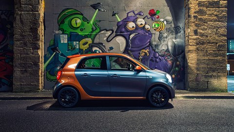 Brightly coloured, misshapen, cartoony design. Next to some graffiti 