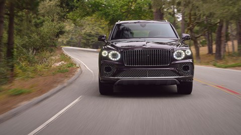 Bentley Bentayga Extended Wheelbase review - dead-on front view, driving round corner, purple