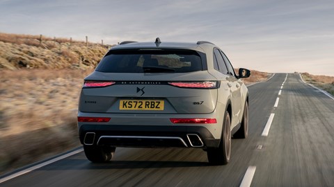 DS 7 (2023) review: rear three quarter tracking shot, grey car, sunset background