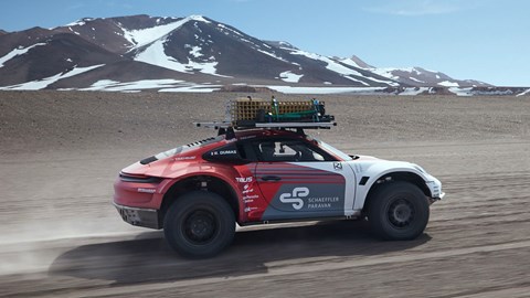 Porsche 911 experimental off-roader, side view, driving with mountains in the background