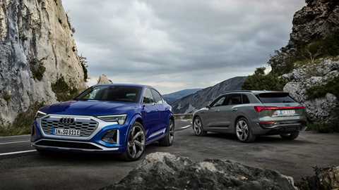 Audi Q8 e-tron SUV and Q8-etron Sportback, parked atop a hilly pass, Sportback in foreground