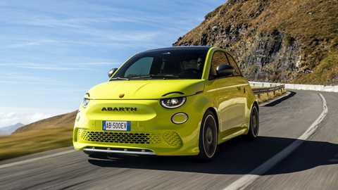 Abarth 500e front three quarter rolling, yellow car, mountain pass