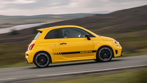 Abarth 595 (2022) review: side view driving shot, yellow car, rural background