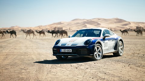 Porsche 911 Dakar in front of camels etc