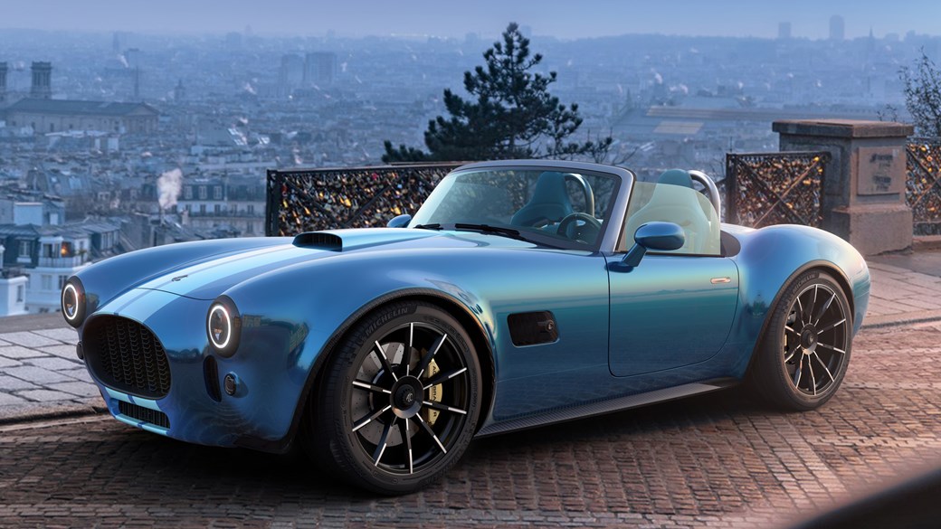 AC Cobra GT Roadster (2023): front three quarter static, blue car, CAD render with a city background