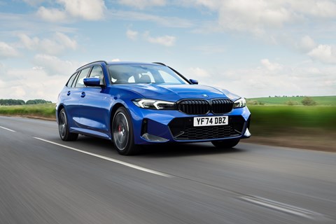 Image of a blue BMW 330e Touring driving along a straight road, viewed from the front right corner
