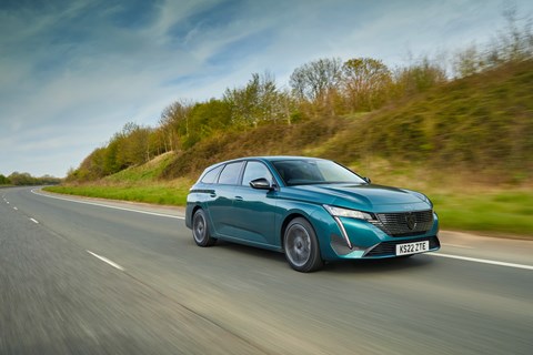 Image of a green Peugeot 308SW driving along a straight road, viewed from the front right corner
