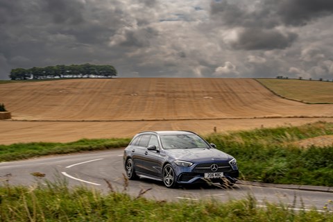 Image of a grey Mercedes-Benz C-Class Estate driving round a right-hand corner, viewed from the front right corner