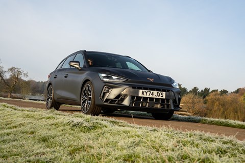 Image of a grey Cupra Leon Estate stood static on a country house driveway, viewed from the front right corner