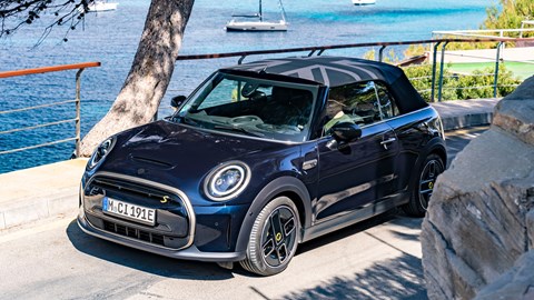 MINI Electric Convertible (2023): front three quarter static, roof up, in front of marina, black paint