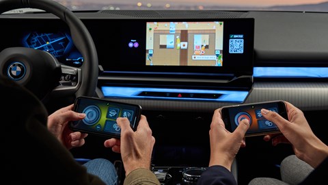 BMW i5: two people playing video games on the i5's infotainment system