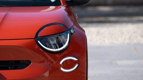 Fiat 600e review: LED headlight close up, orange paint