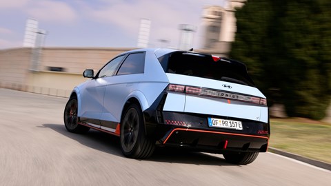 Hyundai Ioniq 5 N (2024) review: rear three quarter driving, low angle, blue paint, Spanish roads