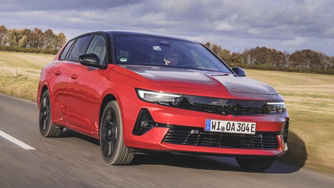 Vauxhall Astra Sports Tourer Electric (2023) review: front three quarter driving, British country lane, red paint
