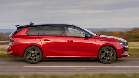 Vauxhall Astra Sports Tourer Electric (2023) review: side view driving, British country lane, red paint
