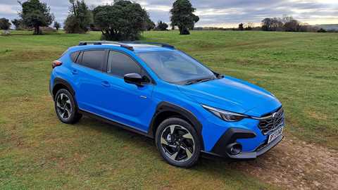 Subaru Crosstrek: front three quarter static, blue paint, in a field