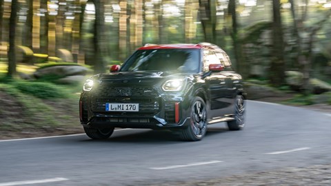 Mini Countryman JCW review - front view, black, driving round corner, lights on
