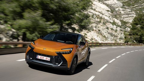Toyota C-HR PHEV (2024) review: front three quarter cornering, high angle orange and black paint, French roads