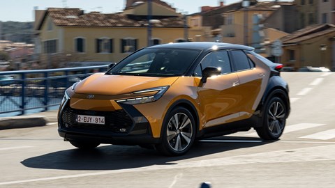 Toyota C-HR PHEV (2024) review: front three quarter cornering, orange and black paint, French town roads
