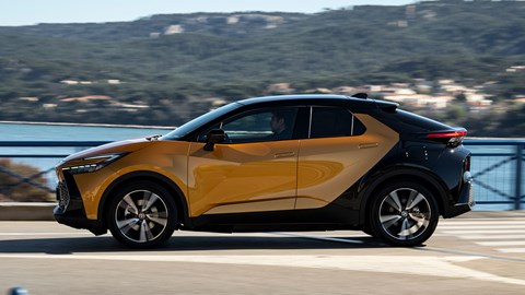 Toyota C-HR PHEV (2024) review: side view driving, orange and black paint, French roads