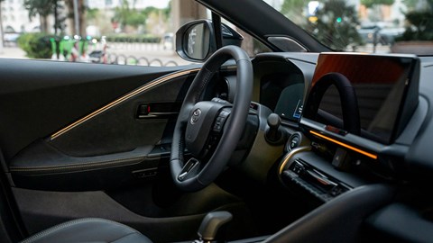 Toyota C-HR PHEV (2024) review: steering wheel and infotainment system, black upholstery