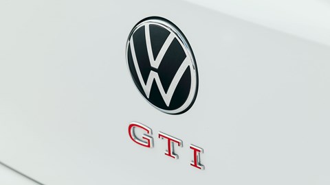 Volkswagen Golf GTI Clubsport, front three quarter static, close-up of badge, white paint