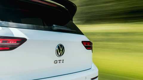 Volkswagen Golf GTI Clubsport, rear three quarter driving, close-up of badge, white paint