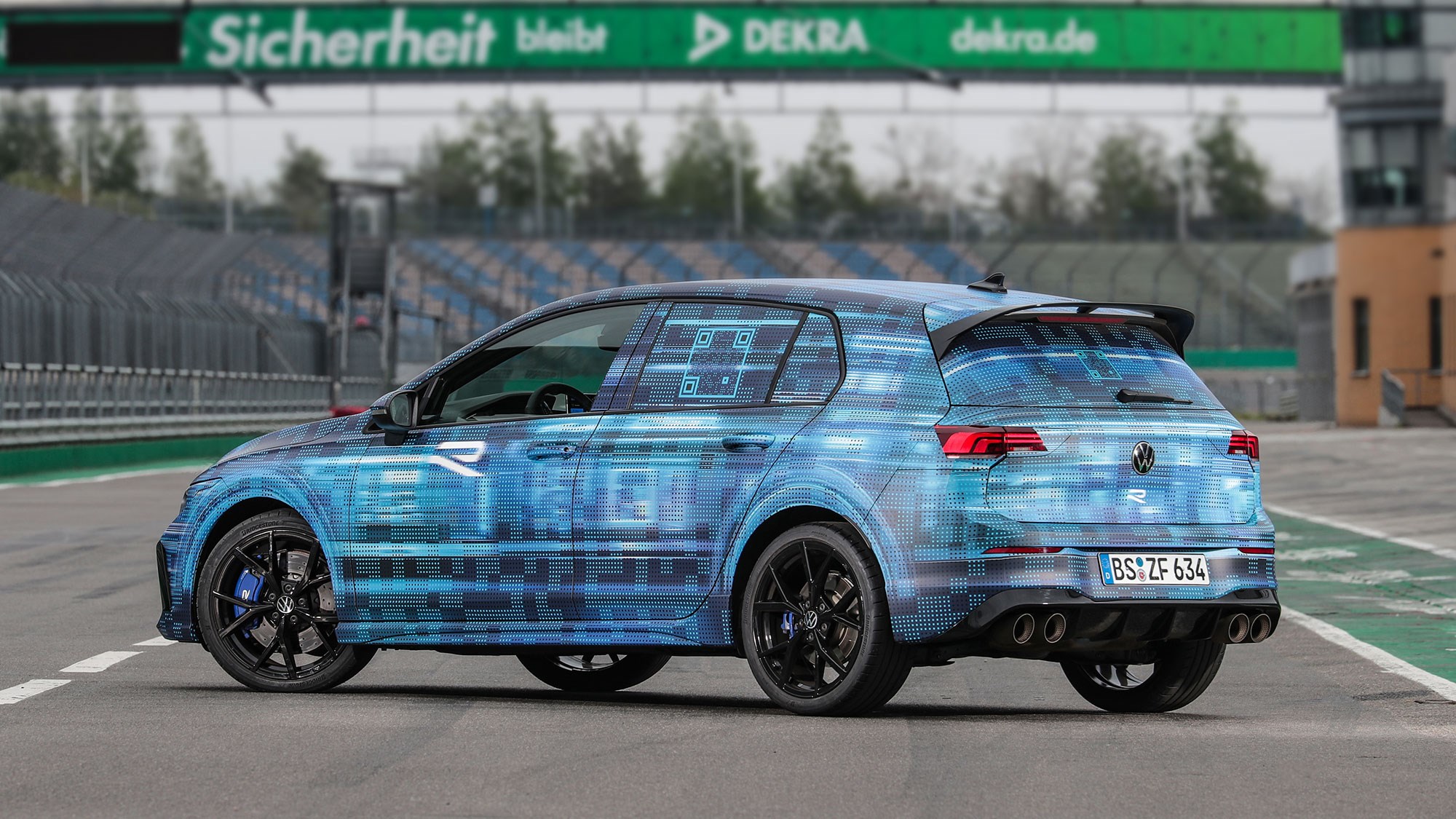 Volkswagen Golf R prototype review: rear three quarter static, on a racetrack, camo wrap