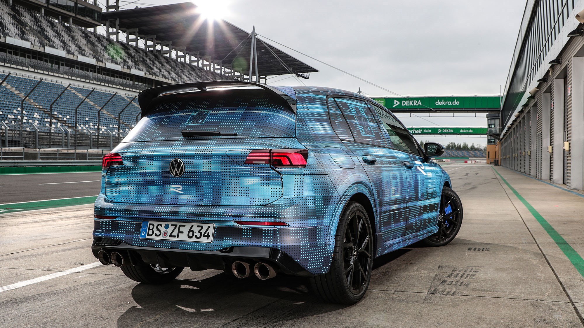 Volkswagen Golf R prototype review: rear three quarter static, low angle, on a racetrack, camo wrap