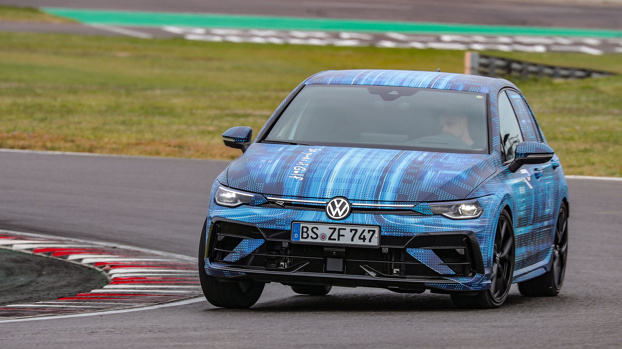 Volkswagen Golf R prototype review: front three quarter cornering, on a race track, almost lifting a back wheel, camo wrap